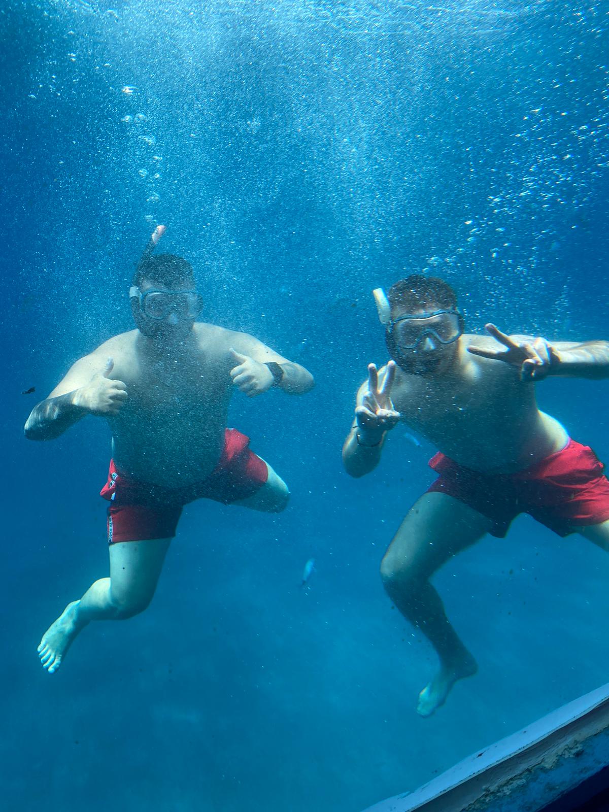 Dos clientes haciendo snorkel vistos bajo el agua
